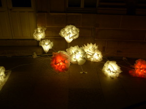 These are paper flowers illuminated from within.  Nighttime art is all about lighting.