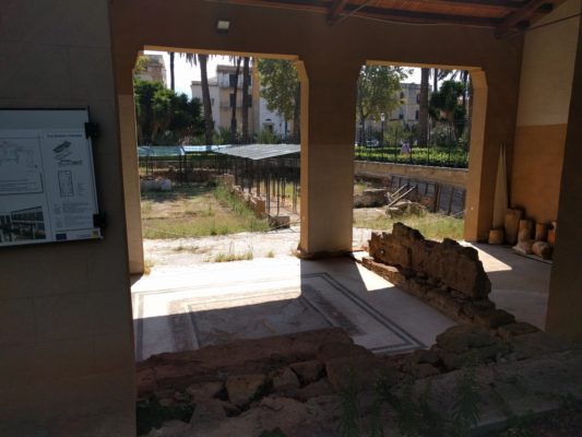 Ancient floor mosaics and foundation walls protected by a new structure