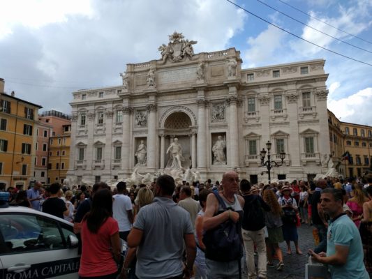 Trevi fountain with a boatload of tourists milling about