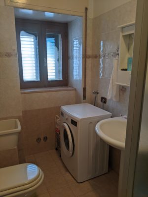 bathroom with a washing machine in the corner