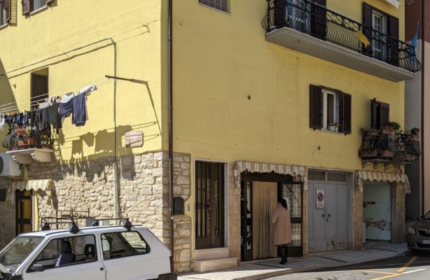 The grocery shop - the door where the customer is entering is the main grocery, next to that is a small garage for a car for the apartment above, and the open area next to that is an annex for the grocery