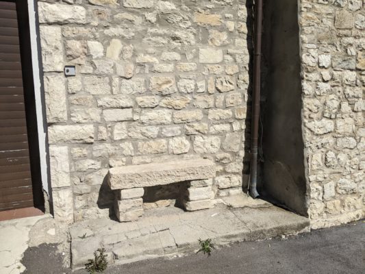 this bench is built onto the side of a house