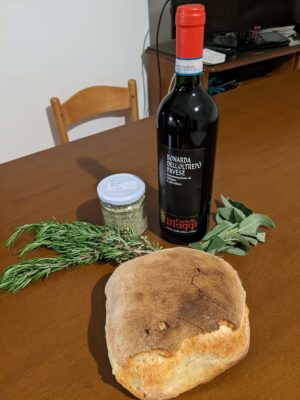 Gifts from Vincenzo - traditional bread, red wine, a jar of oregano, and wild rosemary and sage