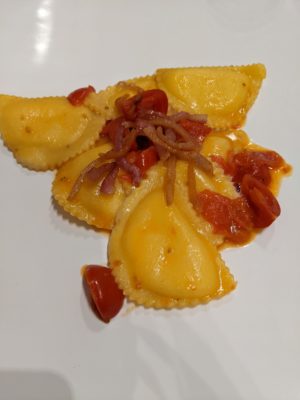 pasta filled with local cheese and topped with cherry tomatoes and crispy seared guanciale (pig's cheeks)