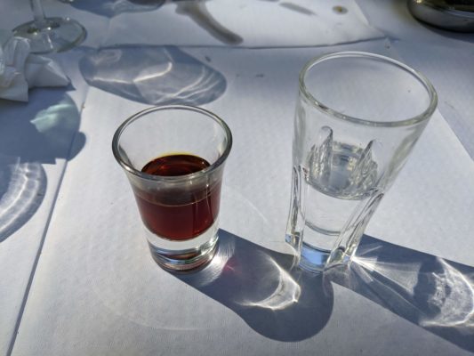 after-dinner drinks - grappa on the right, and on the left is a drink made from citrus and olive leaves