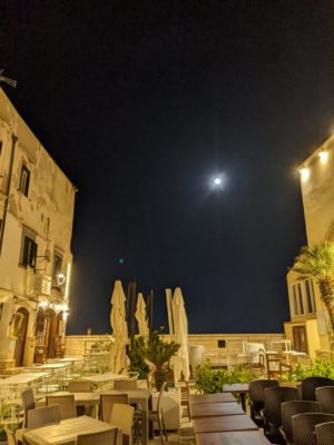 a piazza in the old town with a full moon on display