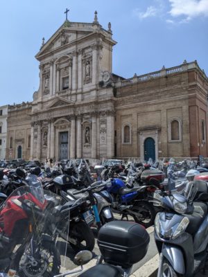 A church plaza filled with motorcycles and scooters