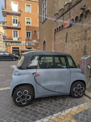 Here's a little 2-person electric car at a charging station.